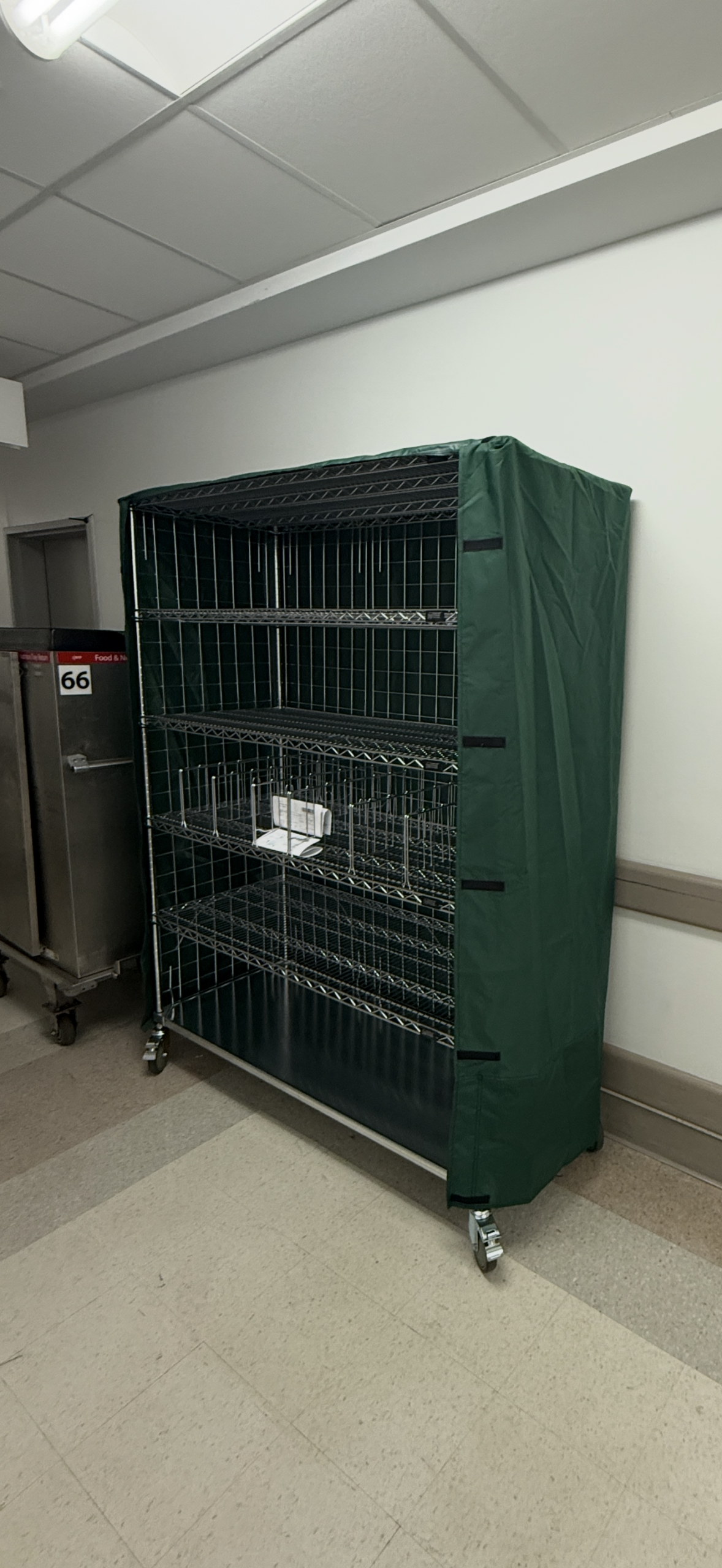 Green-covered wire shelving cart on wheels