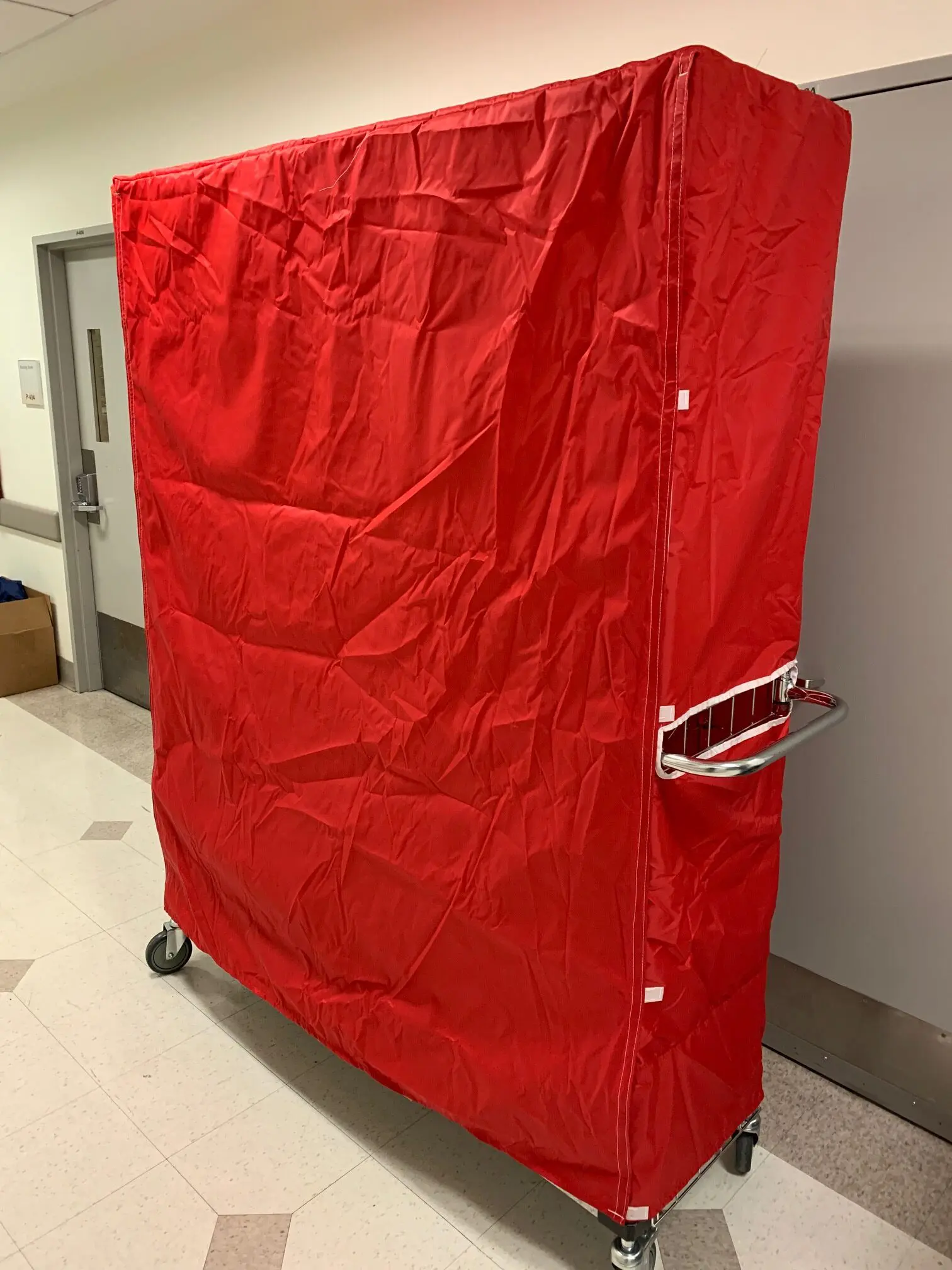 Red-covered rolling laundry cart in hallway