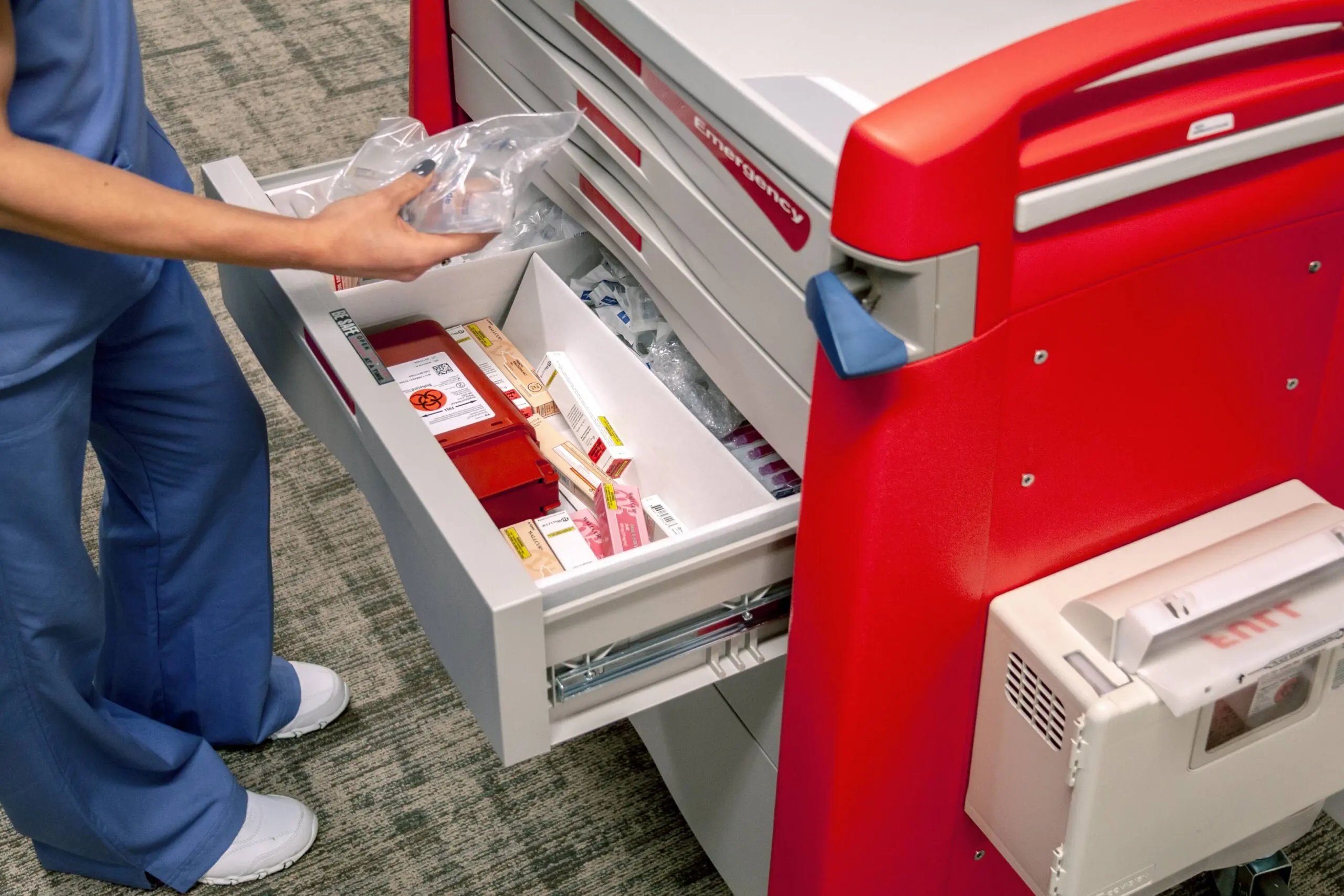Nurse opening emergency medication cart drawer