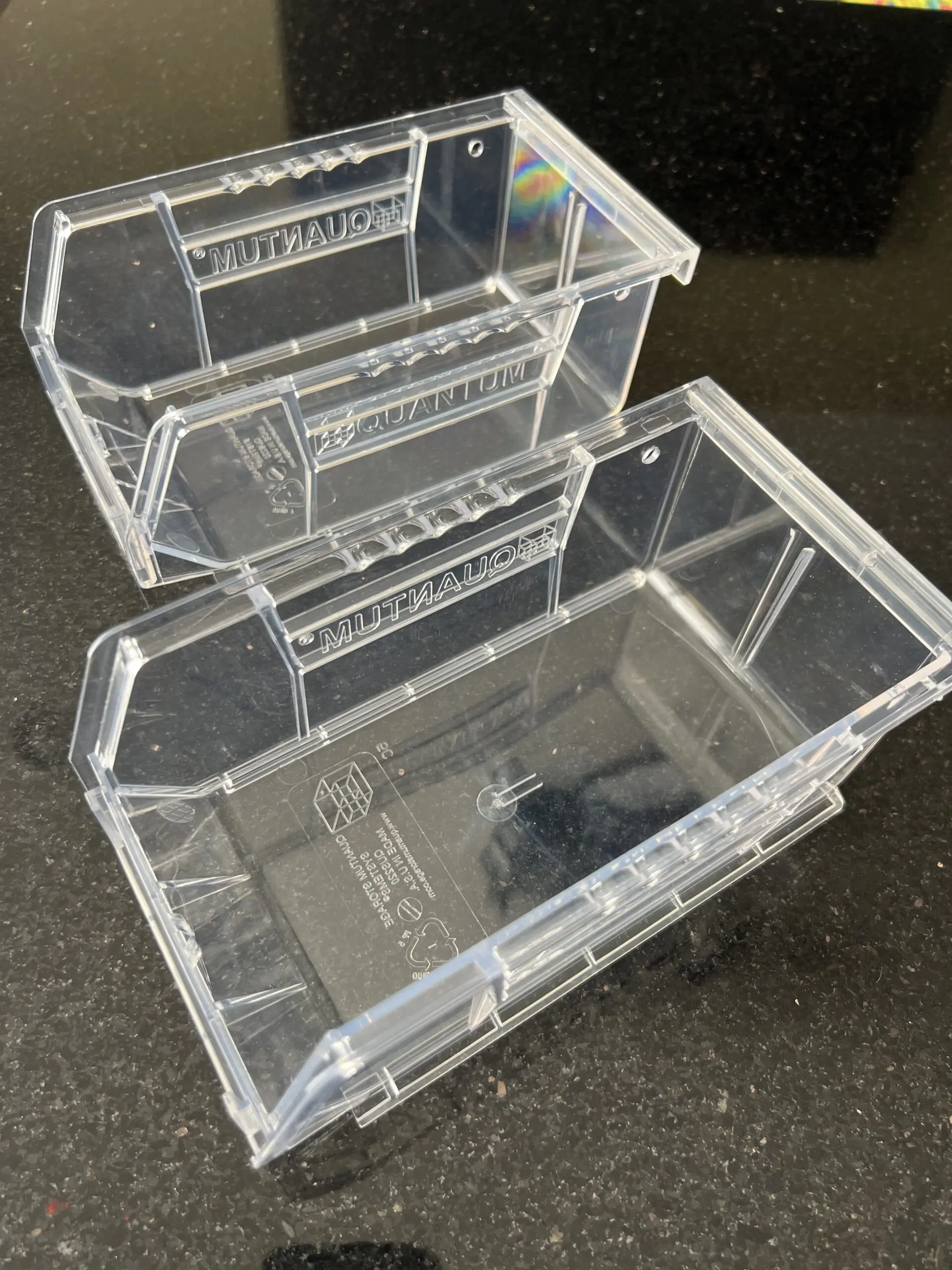 Clear plastic organizer bins on black counter