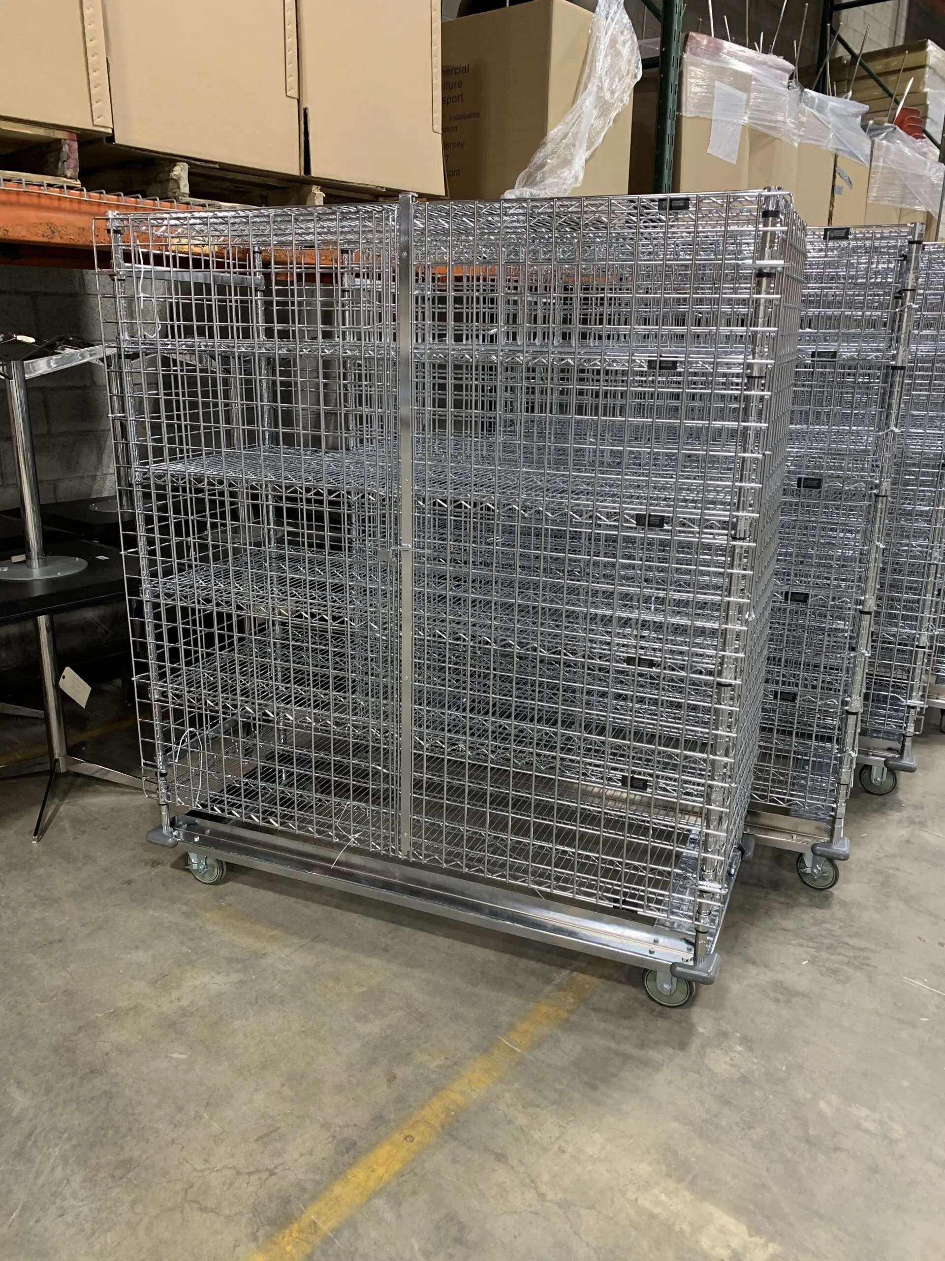 Metal wire rolling storage cages in warehouse