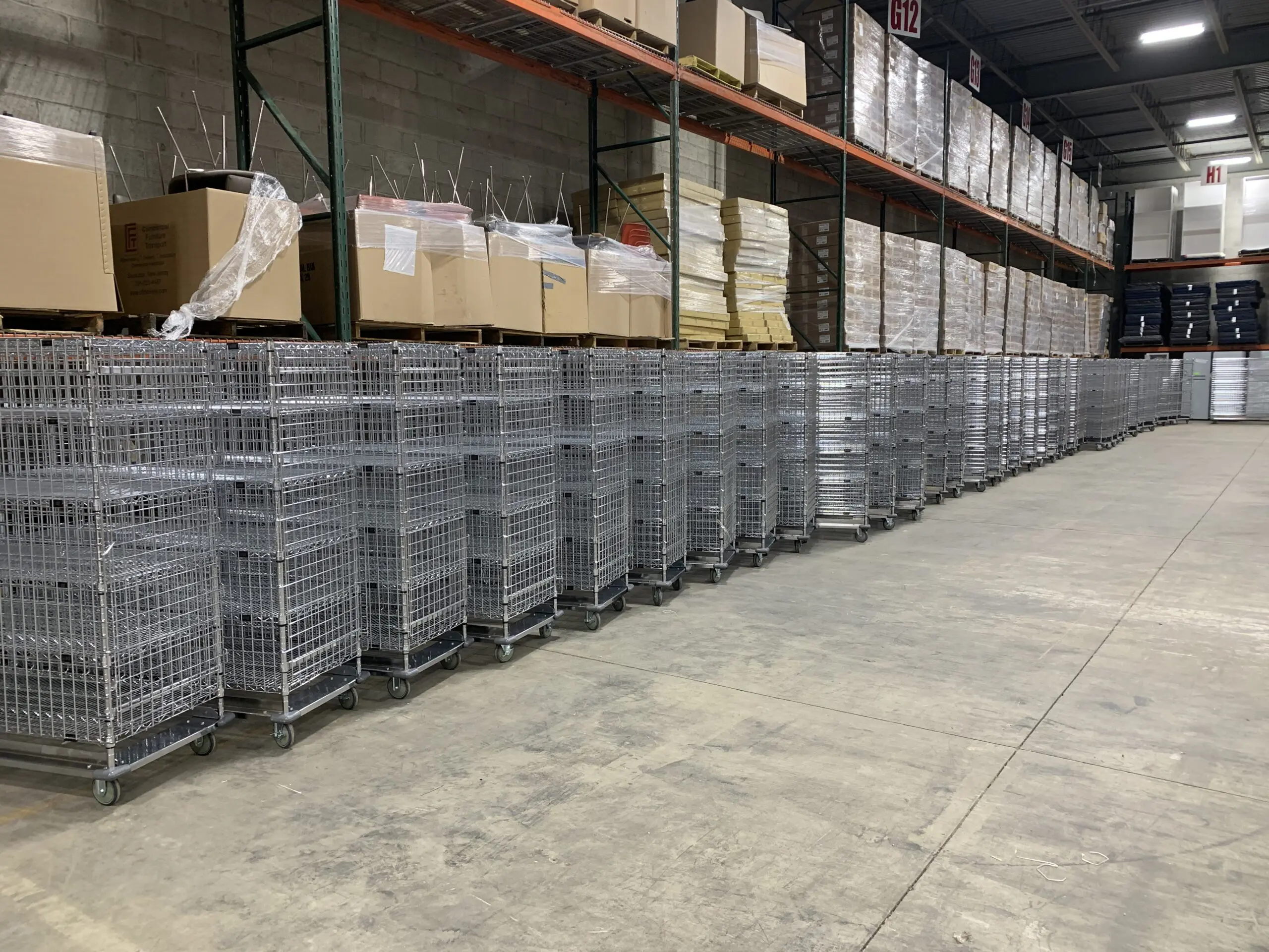 Rows of metal rolling cages in warehouse