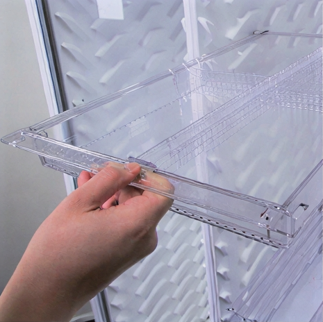 Hand pulling out a transparent acrylic drawer from a cabinet.